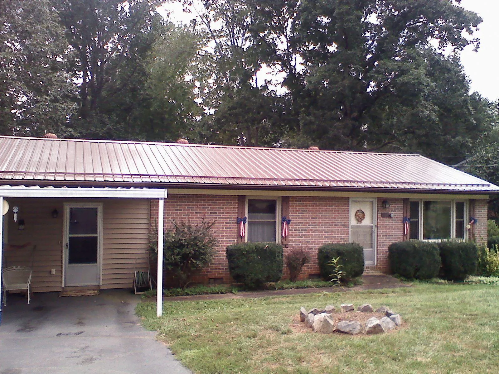 Bronze metal roof and carport on a brick ranch home — Roof Repair work by our crew in Hallwood